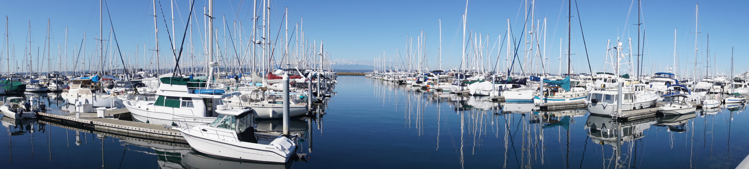 Reflections of sailboats in marina